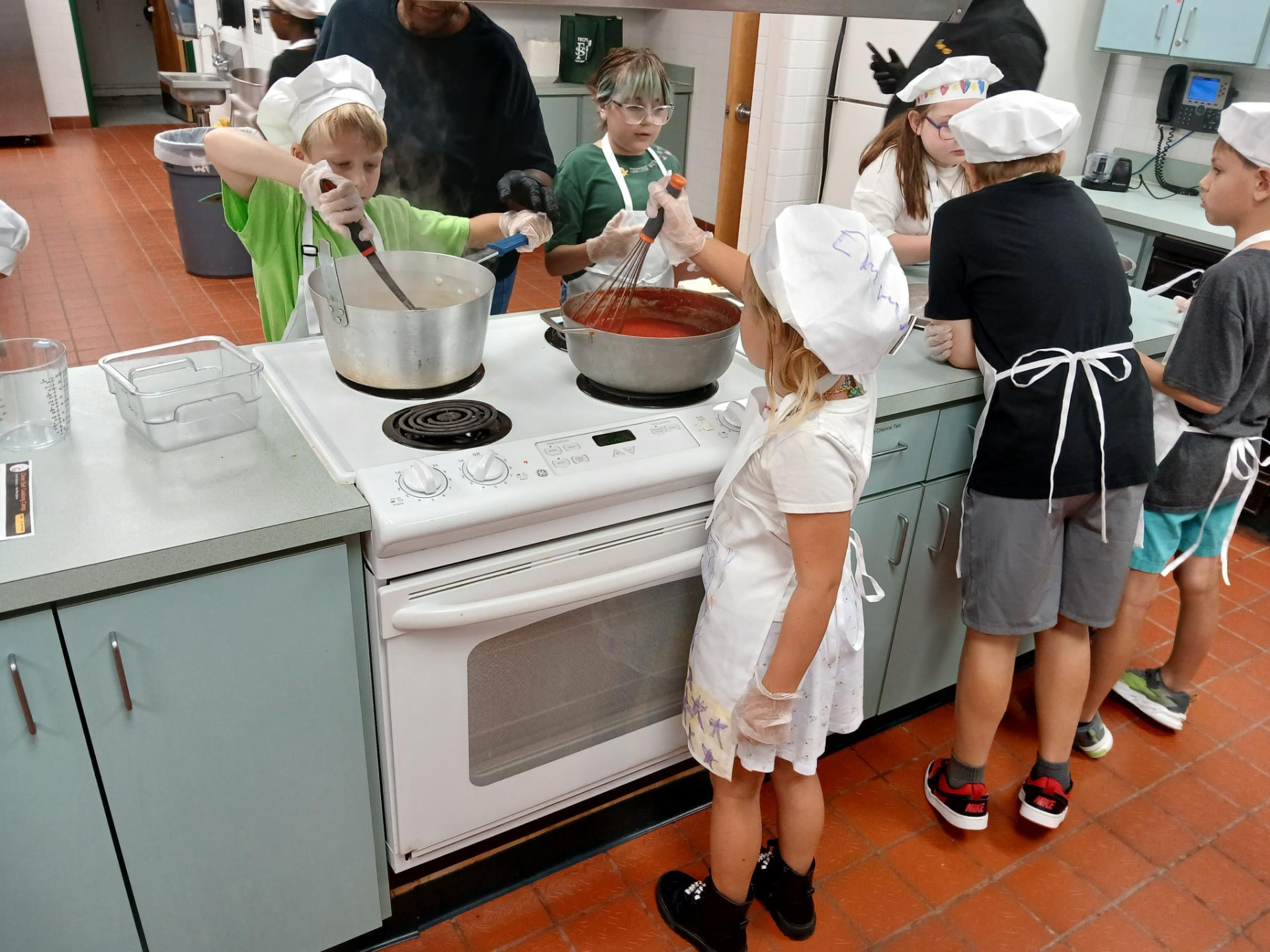 Children and an instructor preparing fresh vegetables together in a Food Fun Club session